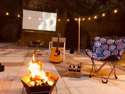a fire pit with a chair and a stage with a screen at Honjin in Izunokuni