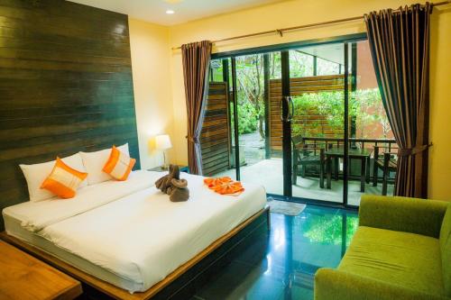 a bedroom with a bed and a chair and a balcony at Leelawadee Lipe Resort in Ko Lipe