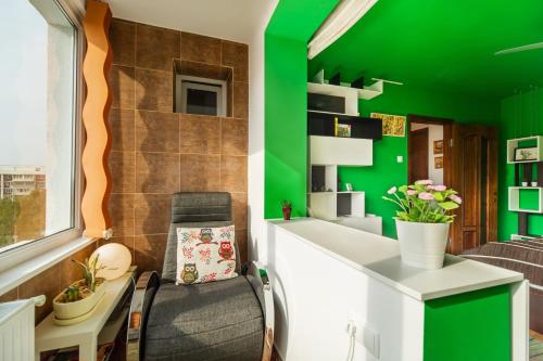 Jest to zielony pokój z biurkiem i zieloną ścianą. w obiekcie Certo Apartment w Braszowie