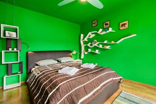 Dormitorio verde con cama con pared verde en Certo Apartment, en Brasov