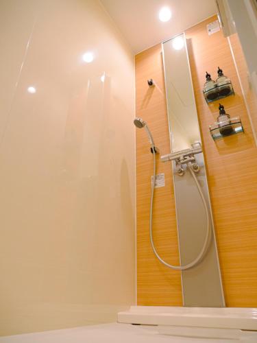 a bathroom with a shower with a mirror at GRAND BASE Beppueki in Beppu
