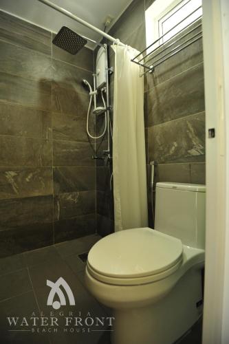 a bathroom with a toilet and a shower at Alegria Water Front Beach House in Alegria