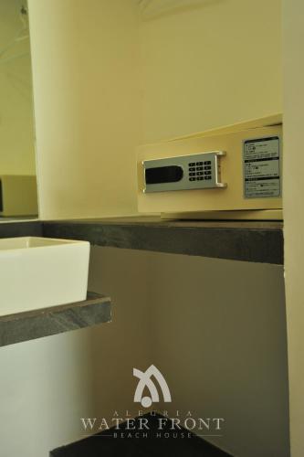 a bathroom with a counter with a sink and a microwave at Alegria Water Front Beach House in Alegria