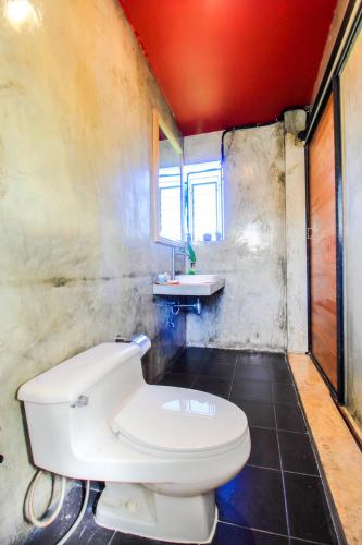 a bathroom with a white toilet and a sink at Plernsalaya resort in Salaya