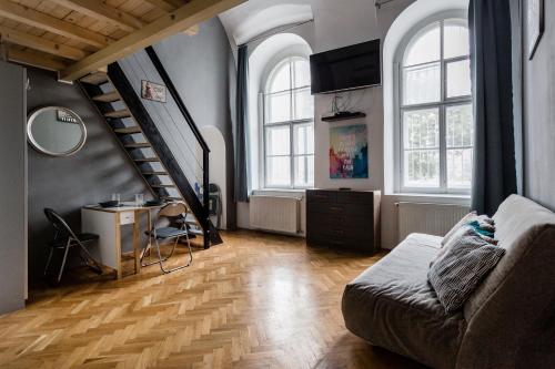 a living room with a couch and a staircase at Mickey's Chain Bridge Apartments in Budapest