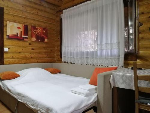 a bedroom with two beds and a window at Wooden House in Veria in Tagarochórion