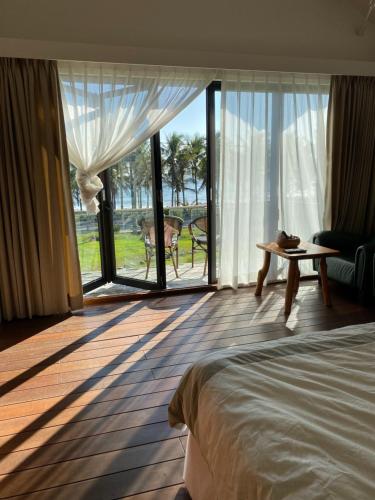 a bedroom with a bed and a view of the ocean at Coconut Beach Homestay in Beinan