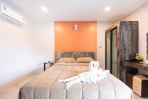 a bedroom with a large bed with a swan on it at Barista Hotel in Uttaradit