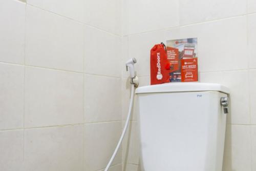 a bathroom with a toilet with a hose at RedDoorz near Widya Mandala University in Surabaya