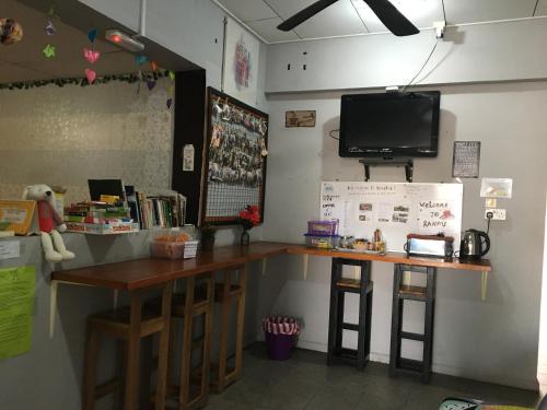 a bar in a room with a tv on the wall at Ranau Backpackers Hostel in Ranau
