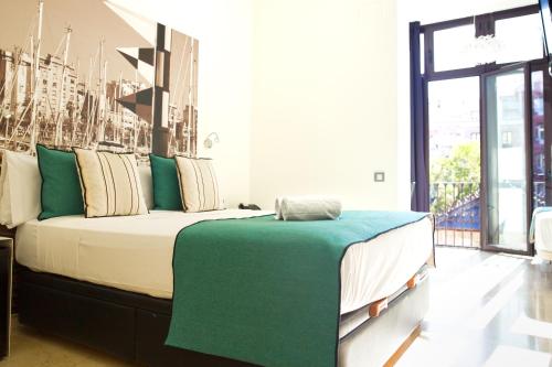 Un dormitorio con una cama grande con almohadas verdes y blancas en Limonaia, en Barcelona