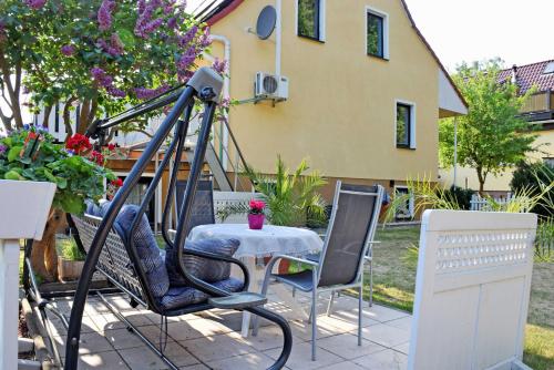 a patio with a table and chairs in front of a house at Ferienwohnung zur Baaber Heide in Baabe