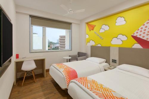 a hotel room with two beds and a window at Ginger Patna in Patna