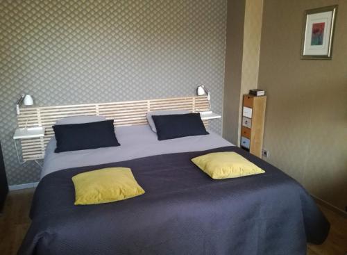 1 cama grande con sábanas azules y almohadas amarillas en B&B de Ferver en Leeuwarden