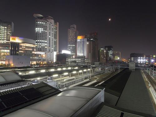 a city skyline at night with a train station at Hearton Hotel Nishi Umeda in Osaka