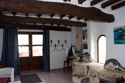 sala de estar con sofá y ventana en L'Almàssera Casa Rural & Restaurant en Margarida
