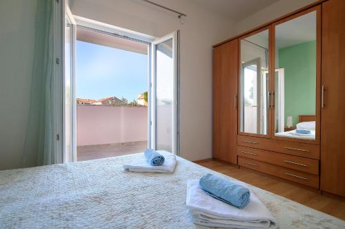 a bedroom with a large bed with towels on it at Apartments Lola in Novalja