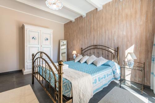 a bedroom with a bed with a blue comforter at Villa Sa Rocca Manna in Chia