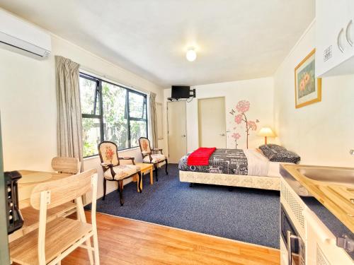 a bedroom with a bed and a desk at Atarau Grove Studio in Paraparaumu