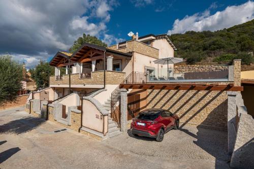 a red car parked in front of a house at Villa Sa Rocca Manna in Chia