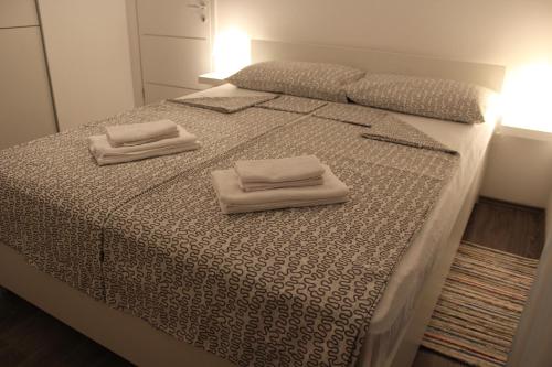 ein Bett mit zwei weißen Handtüchern darüber in der Unterkunft Nicely decorated apartment Silver in Fažana
