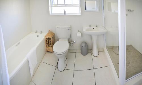 a white bathroom with a toilet and a sink at Adventure House - Colchester - 5km from Elephant Park in Colchester