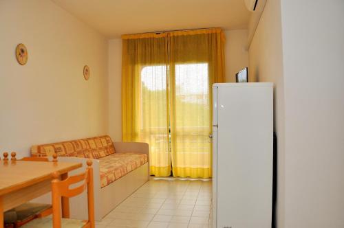 uma sala de estar com um sofá, uma mesa e um frigorífico em Condominio Tonin B em Bibione