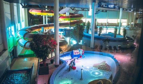 an indoor water slide in a building with a pool at Break Sokos Hotel Flamingo in Vantaa