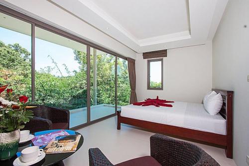 a bedroom with a bed and a table with chairs at 2 Bedroom Pool Villa in Quiet Location SDV005-By Samui Dream Villas in Mae Nam