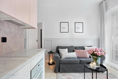 a kitchen and living room with a gray couch at Elite Apartments Old Town Ogarna Premium in Gdańsk
