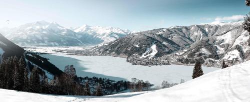 a view of a snow covered mountain with a lake at Simone's Platzerl - inklusive täglichem freien Eintritt Tauern Spa - nur 5 Gehminuten, Sommerkarte, privatem Garten mit Schwimmteich, Grill und Saunabereich in Kaprun