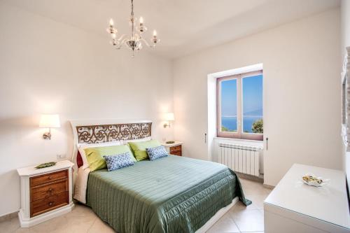 een witte slaapkamer met een bed en een raam bij MEDITERRANEAN HOUSE in Sorrento