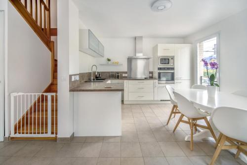 une cuisine avec des armoires blanches et une table et des chaises dans l'établissement Appartement de 4 chambres à 13 minutes de Paris (train), à Juvisy-sur-Orge