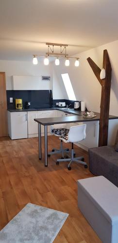 a living room with a table and a kitchen at Villa Rynek in Góra Świętej Anny