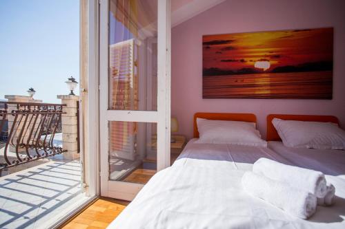 a bedroom with a bed and a view of a balcony at Apartments Villa Paradise in Kaštela