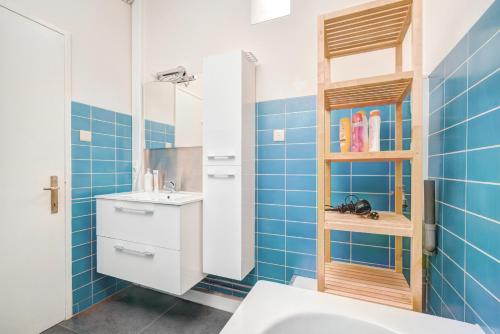 bagno piastrellato blu con lavandino e specchio di The Grand Apartment. Center of Antwerp ad Anversa