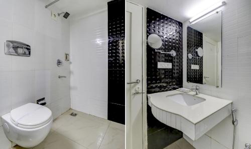 a white bathroom with a toilet and a sink at Hotel Luciya in Cochin