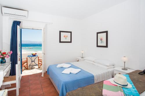 a bedroom with a bed and a view of the ocean at Paros Philoxenia in Chrissi Akti