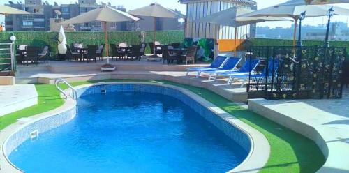 een groot zwembad met blauw water in een tuin bij Hor Moheb Hotel in Caïro