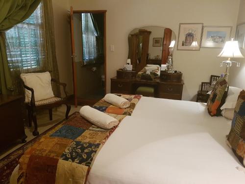 a bedroom with two beds and a mirror at Steytlerville Villa Guest house in Steytlerville