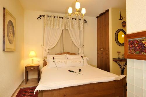 a bedroom with a bed with white sheets and a window at Nichochot Provence in Had Nes