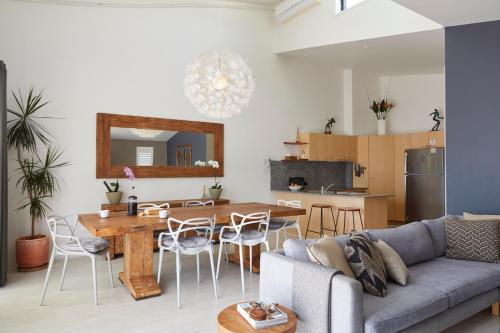 ein Wohnzimmer mit einem Sofa und einem Tisch in der Unterkunft Byron Quarter Apartments in Byron Bay