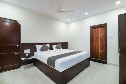 sypialnia z dużym łóżkiem i drewnianymi drzwiami w obiekcie Sri Raghavendra Inn w mieście Visakhapatnam