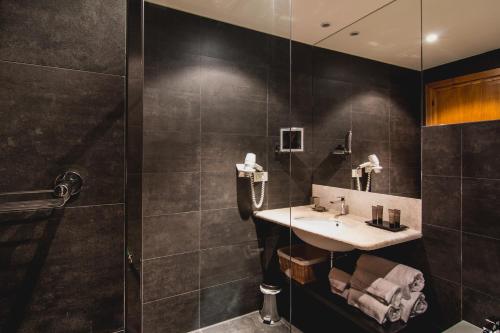 a bathroom with a sink and a shower at Hotel Aquadulci in Chia