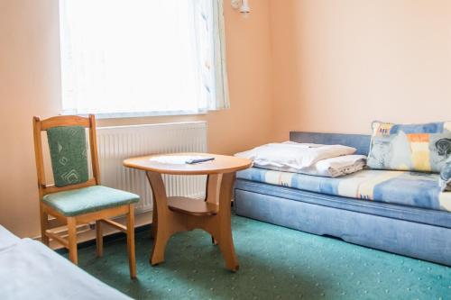 a room with a table and a chair and a couch at Zosienka - pokoje gościnne in Wisła