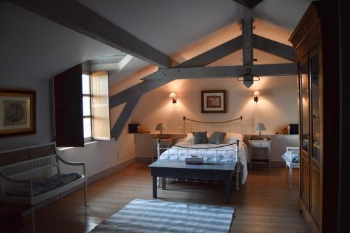 a bedroom with a bed and a table in it at Les Écuries de Saint Sever in Saint-Sever