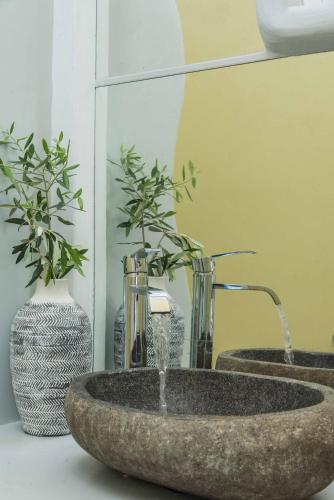 a bathroom with two sinks and two vases at Perla Suites - Delmar Collection in Pollonia