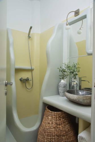a bathroom with a sink and a mirror at Perla Suites - Delmar Collection in Pollonia