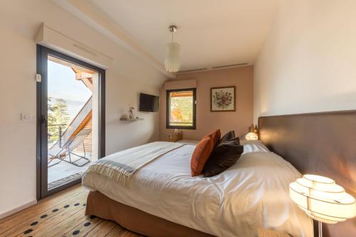 una camera con un grande letto e una grande finestra di Le Port-Plage residence facing Talloires Beach, LLA Selections by Location lac Annecy a Talloires