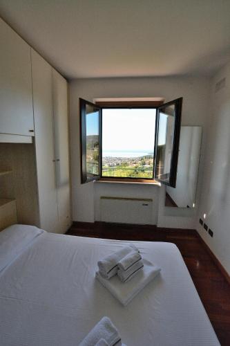a bedroom with a white bed and a window at Casa Montegolo in Costermano